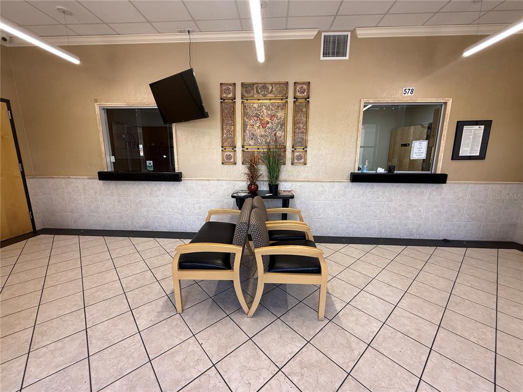 A waiting room features tiled floors, two back-to-back chairs, and two service windows — 578 OCOEE COMMERCE PARKWAY, OCOEE, FL