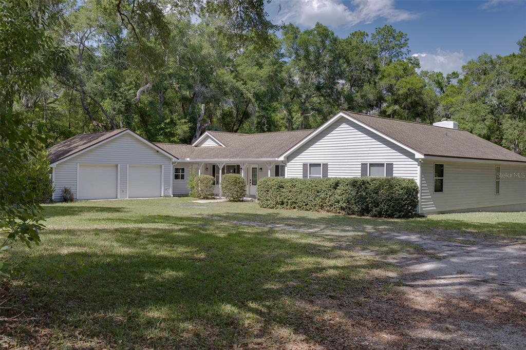 A single-story house with light siding, a two-car garage, and a large front yard — 39 WOOD RIDGE DRIVE, OCALA, FL