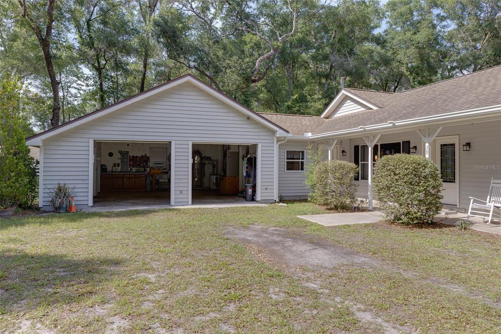A light gray house features an open two-car garage and a covered front porch — 39 WOOD RIDGE DRIVE, OCALA, FL
