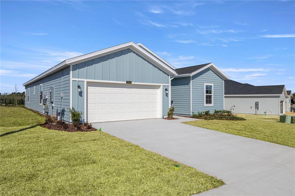 A blue, single-story house with a two-car garage and a concrete driveway — 14358 NW CONVERGENCE BOULEVARD, ALACHUA, FL