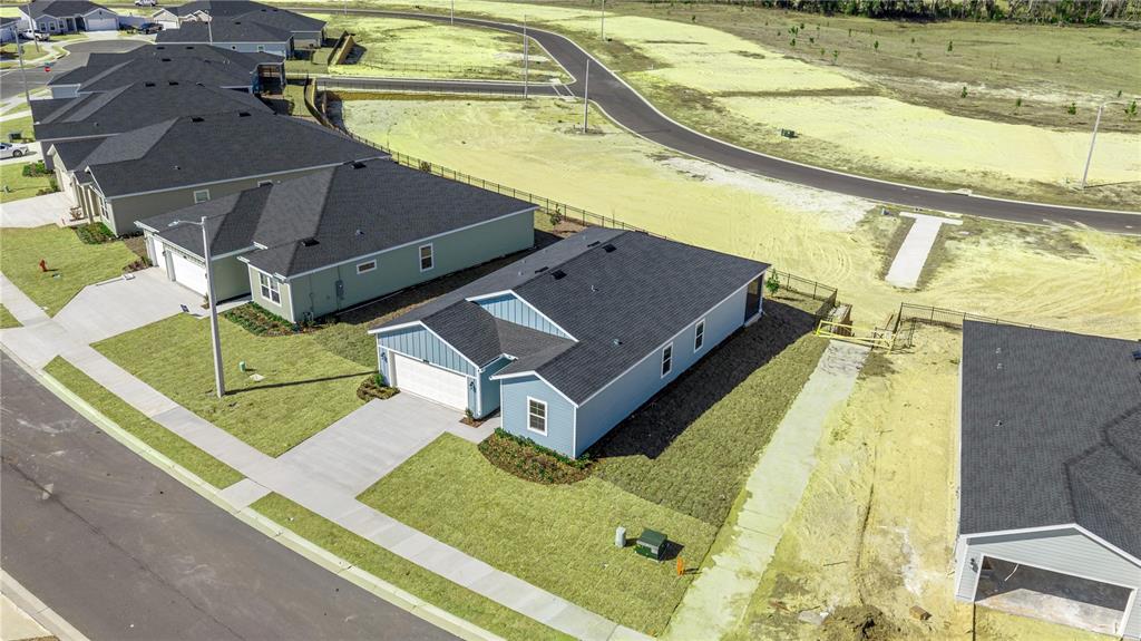 An aerial view shows several suburban houses with dark roofs and driveways in a neighborhood — 14358 NW CONVERGENCE BOULEVARD, ALACHUA, FL