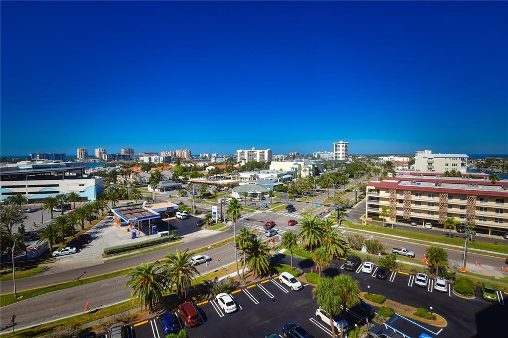 An elevated view of a coastal town featuring a gas station, parking lots, and buildings — 51 ISLAND WAY UNIT 909, CLEARWATER, FL