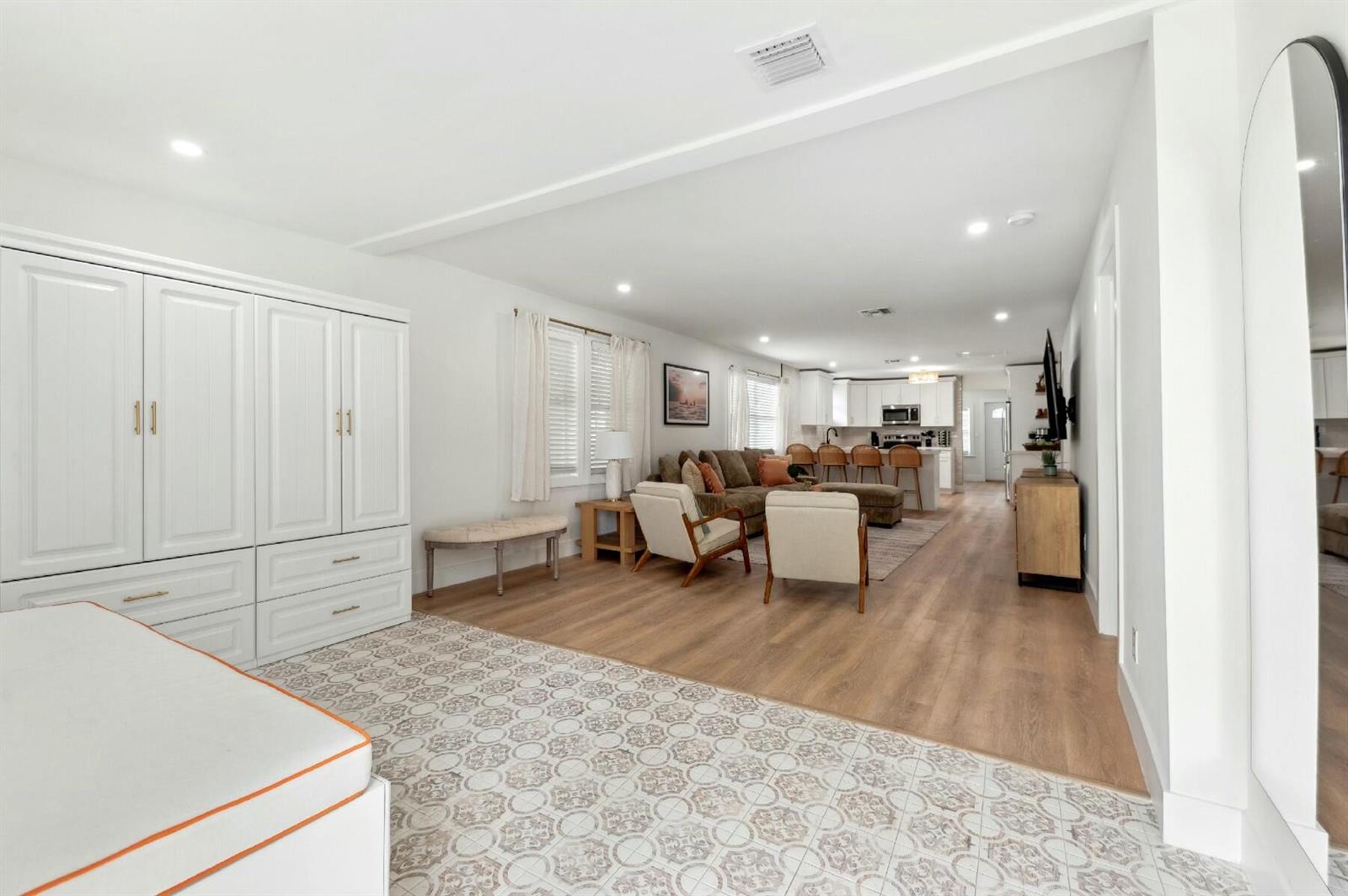 An open-concept living room and kitchen area with light wood floors and white cabinetry — 125 NW 3rd Avenue, Delray Beach FL 33444, DELRAY BEACH, FL