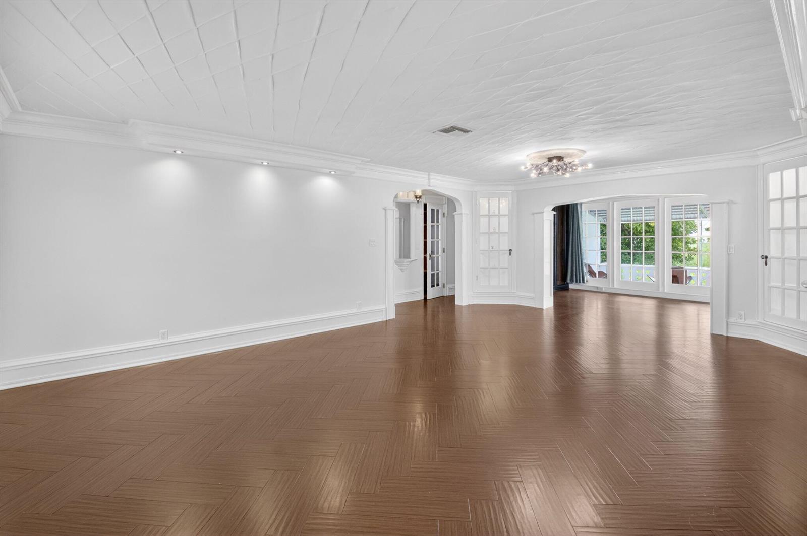 An empty room with white walls, a patterned ceiling, and dark wood herringbone floors — 105 NW 8th Place, Boynton Beach FL 33426, BOYNTON BEACH, FL