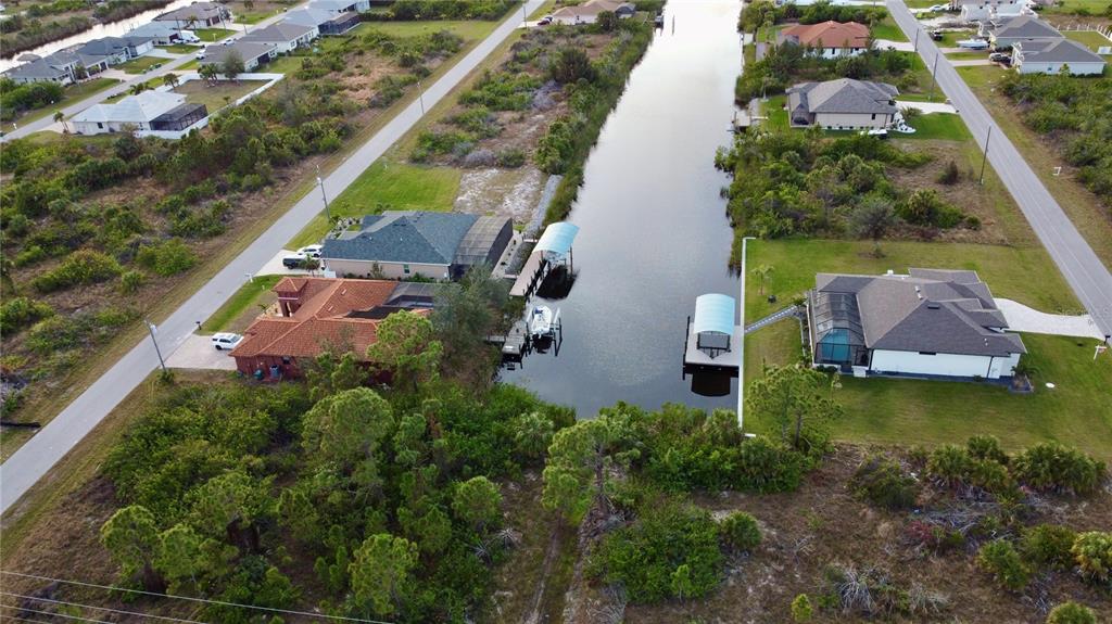 An aerial view shows houses along a canal with boat docks and boat lifts — 10273 ST PAUL DRIVE, PORT CHARLOTTE, FL