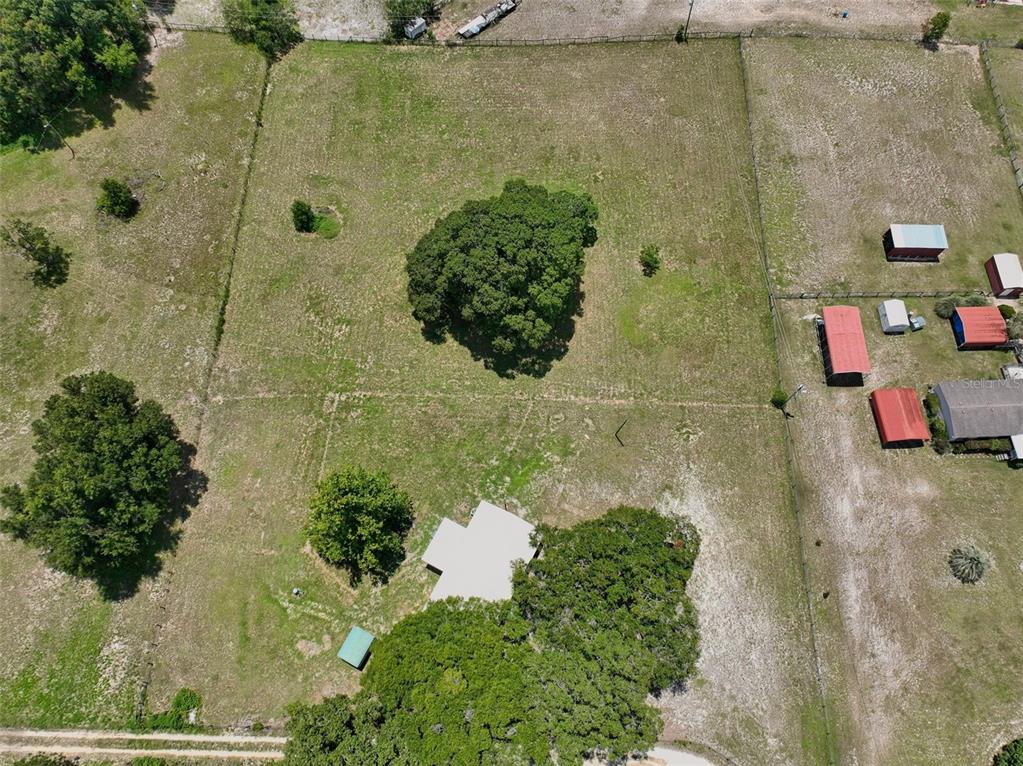 An aerial view shows a house on a large, grassy lot with several trees — 18546 NE 5TH TERRACE ROAD, CITRA, FL