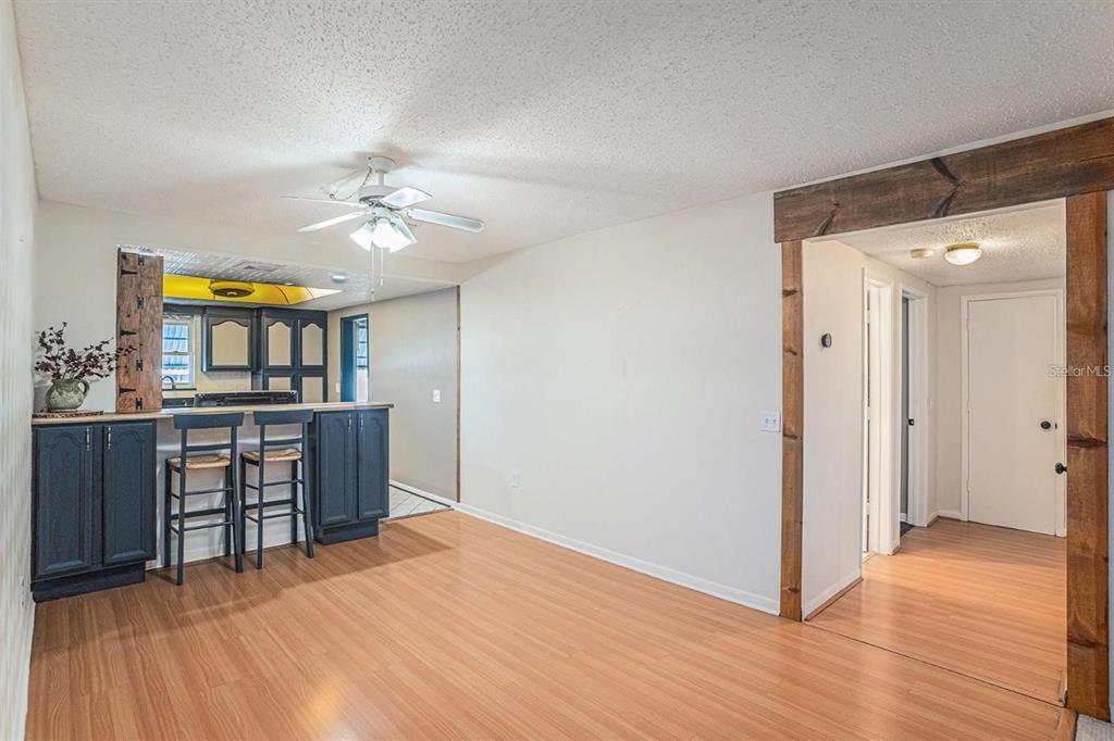 A dining area features wood-look flooring, a breakfast bar with dark cabinets, and a ceiling fan — 1900 59TH AVENUE N UNIT 210, ST PETERSBURG, FL
