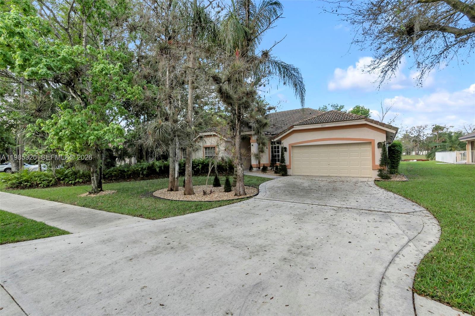 A single-story house with a beige stucco exterior, a tile roof, and a two-car garage — 4927 NW 67th Ave, Lauderhill FL 33319, LAUDERHILL, FL