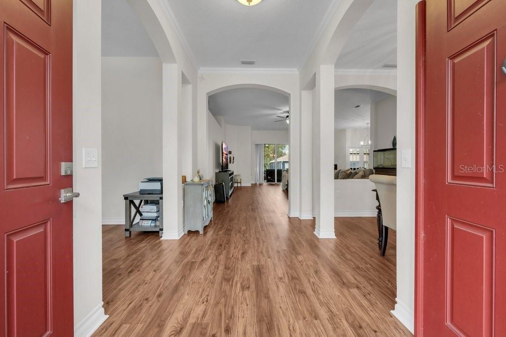 A view from a red front door into a home with wood-look flooring — 16135 BRIDGEDALE DRIVE, LITHIA, FL