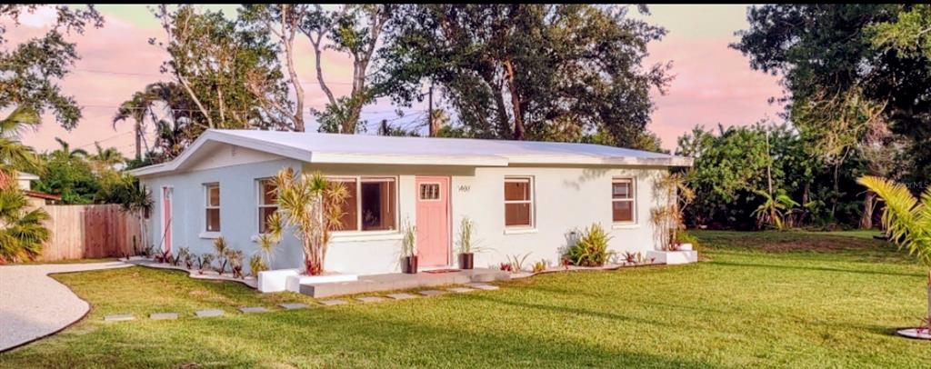 A light blue, single-story house with a pink front door and a white roof — 1407 CORAL RIDGE DRIVE, PUNTA GORDA, FL