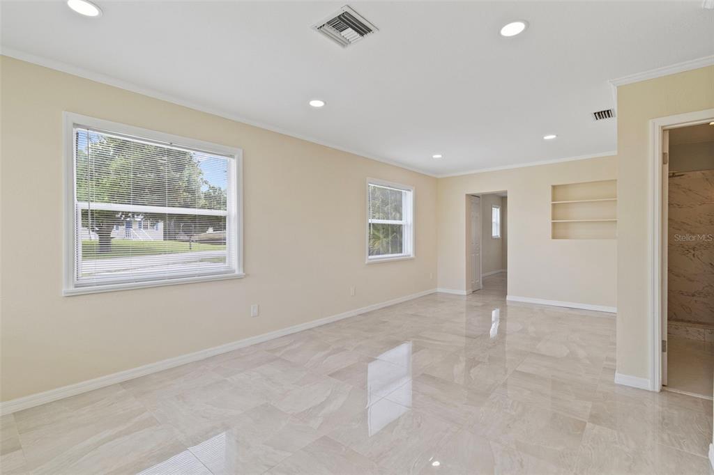 A bright room with beige walls, recessed lighting, and light-colored tile flooring — 1407 CORAL RIDGE DRIVE, PUNTA GORDA, FL