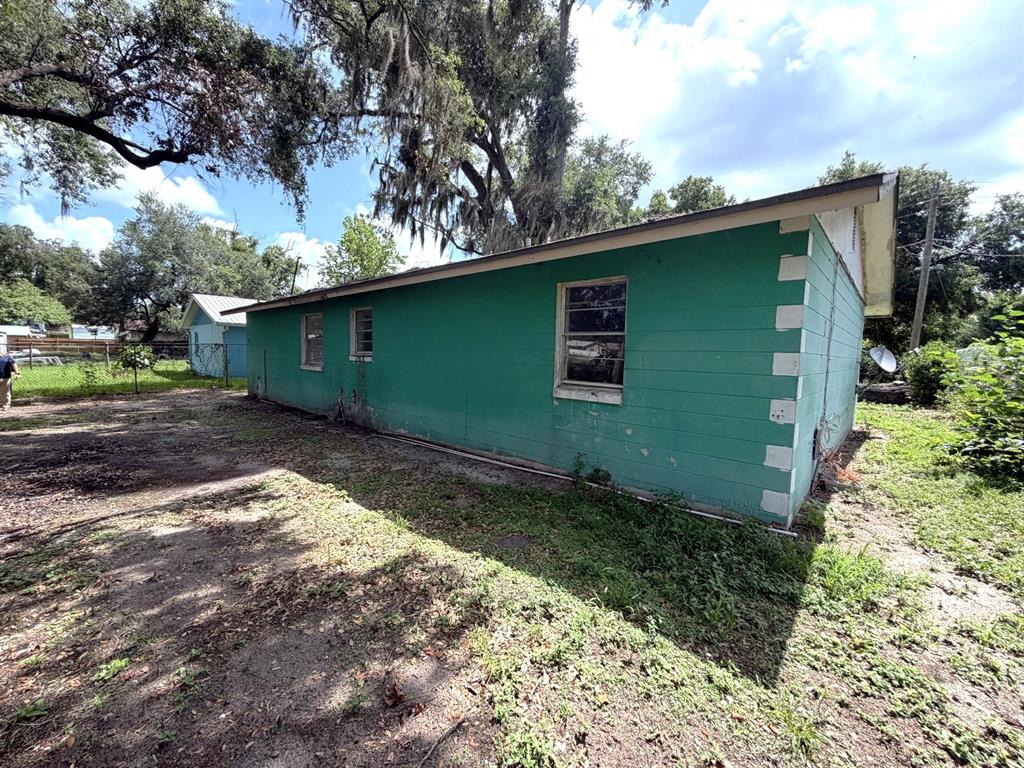 The exterior of a green, single-story house with white corner accents and three windows — 14741 12TH STREET, DADE CITY, FL
