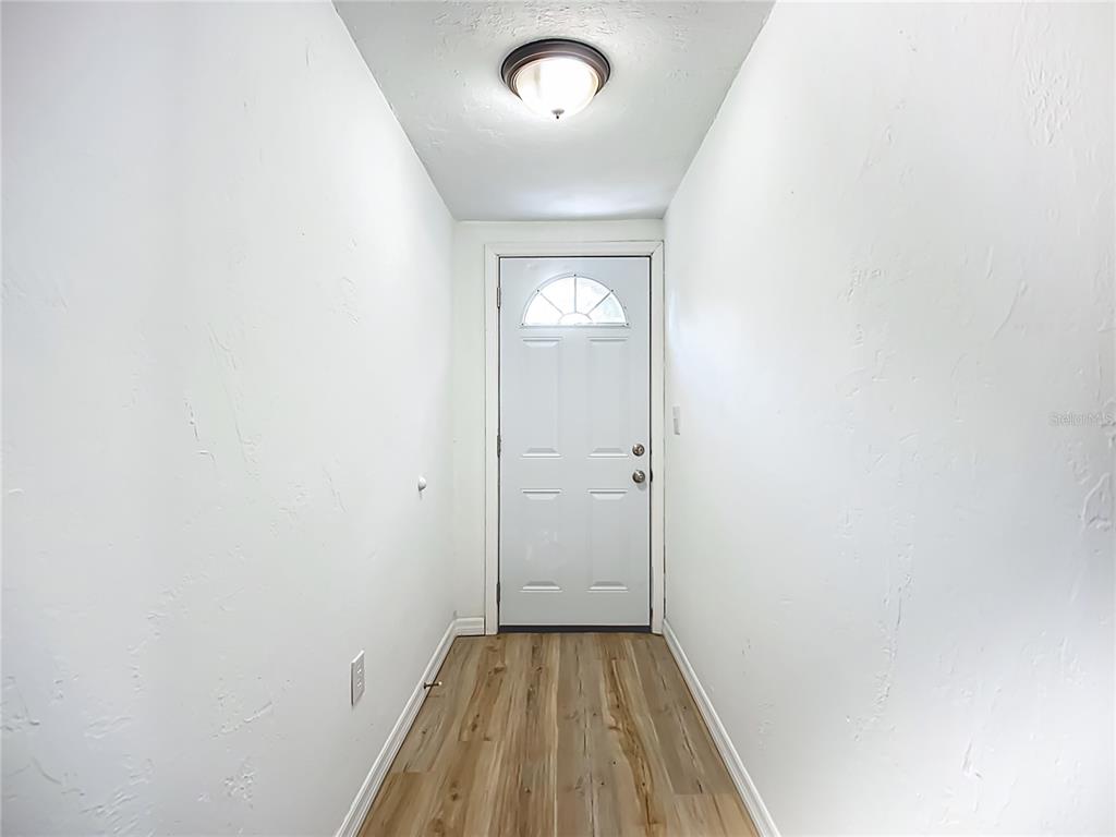 A narrow entryway features white walls, a flush-mount ceiling light, and wood-look flooring — 317 JESSICA STREET S, NOKOMIS, FL
