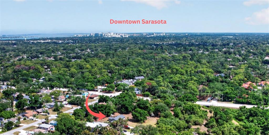 This aerial view shows a residential property surrounded by dense trees near downtown Sarasota — 4842 NUTMEG AVENUE, SARASOTA, FL
