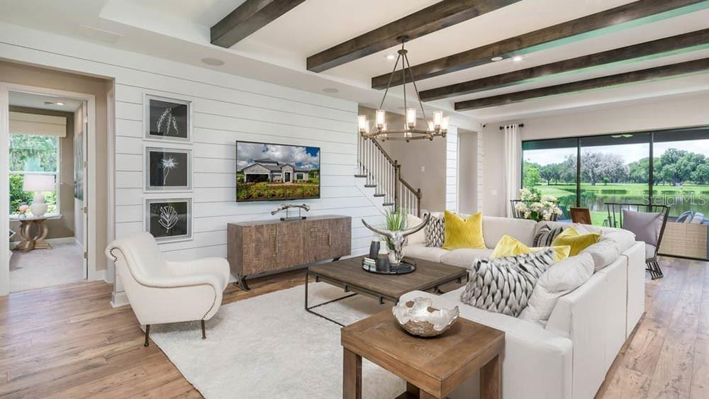 A living room features white shiplap walls, exposed ceiling beams, a sectional sofa, and large windows — 113 ARMOYAN DRIVE, PALM COAST, FL