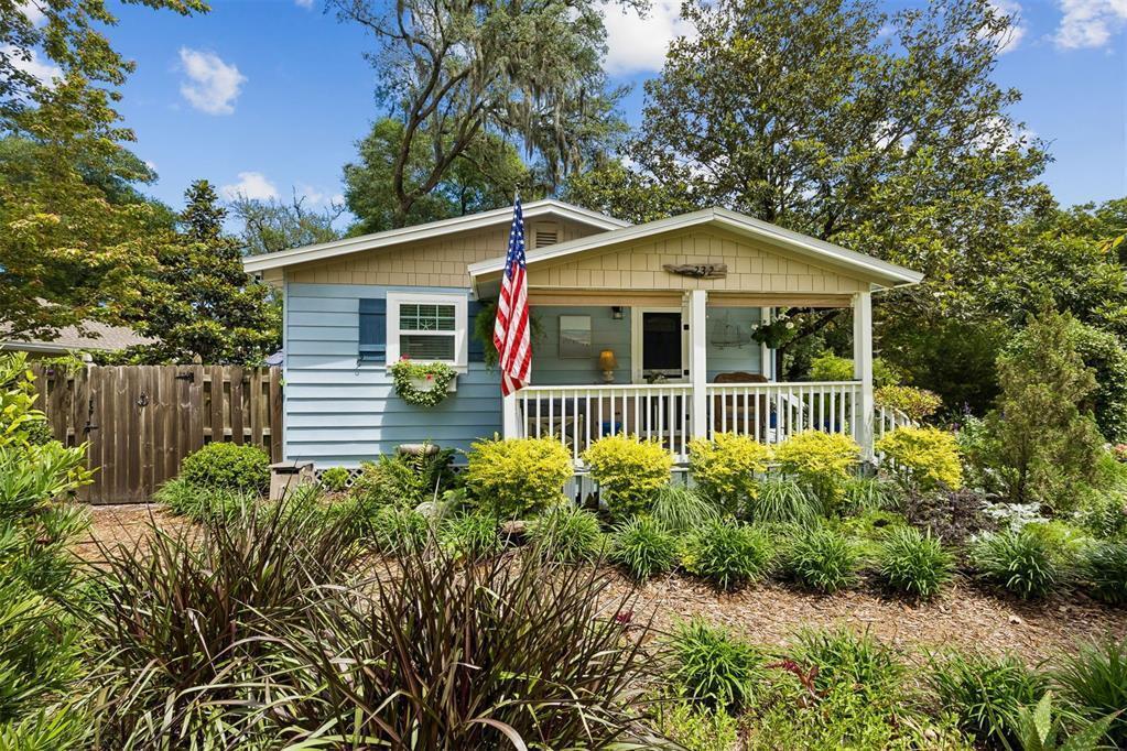 A light blue cottage with a front porch, American flag, and landscaped yard — 232 Vernon Street, FL 32034, FL