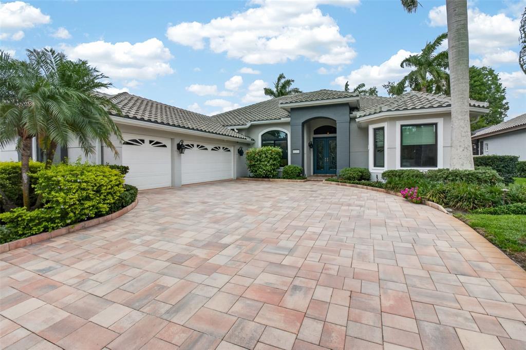 A single-story house with a paved driveway, two-car garage, and a dark gray entryway — 820 SAND PINE DRIVE NE, ST PETERSBURG, FL