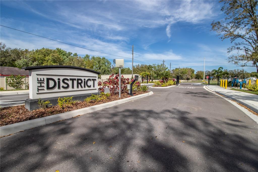 A sign for The District stands at the entrance to a paved residential community road — 3333 PLEASANT WILLOW COURT, BRANDON, FL