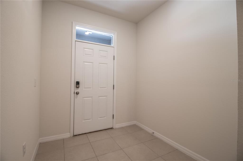 An entryway features a white door with a transom window and light-colored tile flooring — 3333 PLEASANT WILLOW COURT, BRANDON, FL