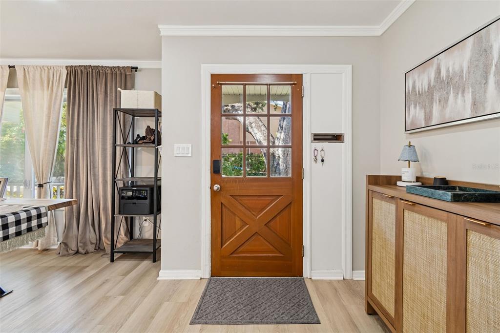 An entryway features a wooden front door with glass panes, light flooring, and a cabinet — 2302 S ARRAWANA AVENUE, TAMPA, FL