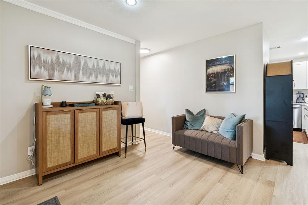 A room features light wood flooring, a wooden cabinet, and a small brown sofa — 2302 S ARRAWANA AVENUE, TAMPA, FL
