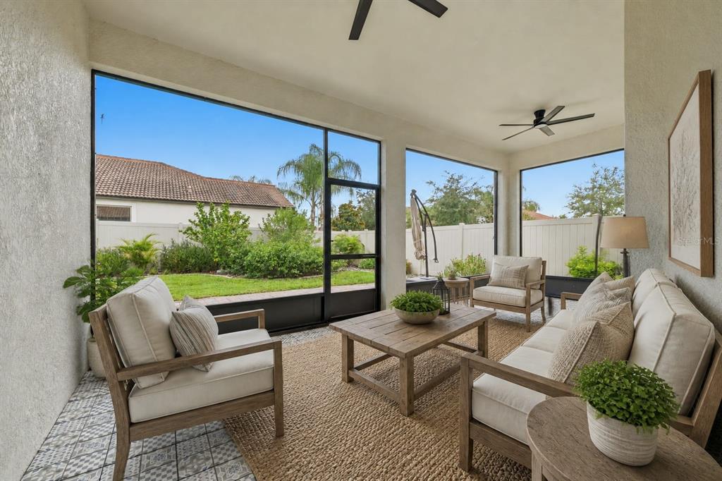 A screened-in patio features outdoor furniture, a patterned tile floor, and views of a backyard — 16920 SCUBA CREST STREET, WIMAUMA, FL