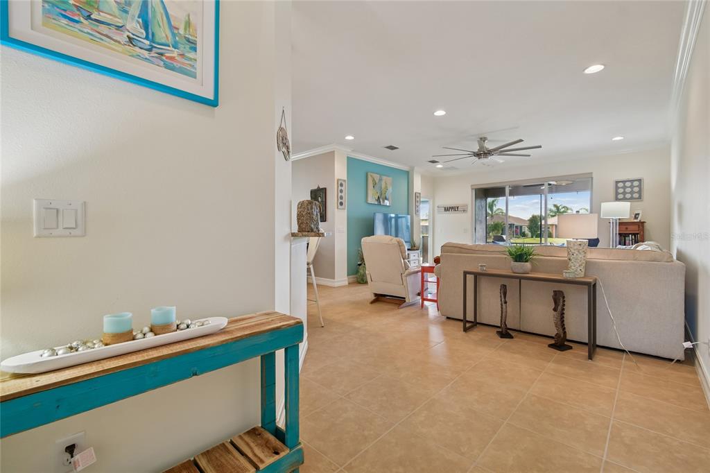 A living room with tile floors, a beige sofa, and a teal accent wall — 4834 MARBLE SPRINGS CIRCLE, WIMAUMA, FL