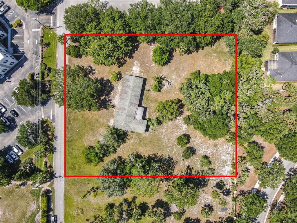A single-story white house with green shutters and a shingled roof sits on a lawn — 10 MIRROR LAKE DRIVE, ORMOND BEACH, FL