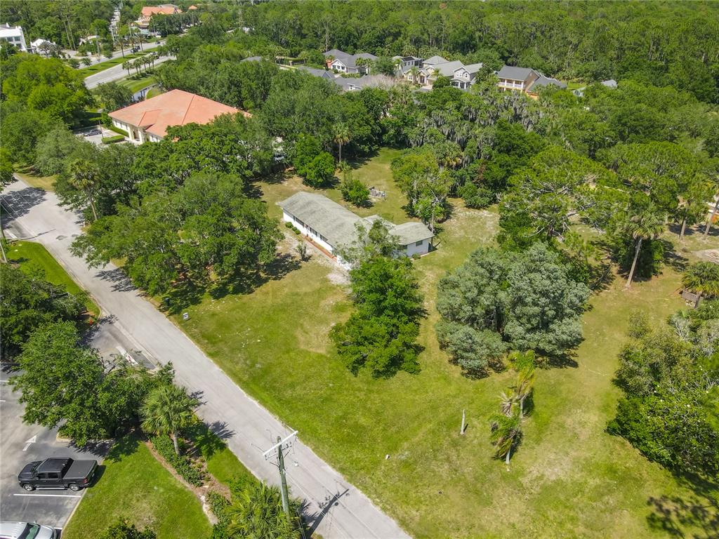 An aerial view of a white, single-story ranch-style house surrounded by trees and grass — 10 MIRROR LAKE DRIVE, ORMOND BEACH, FL
