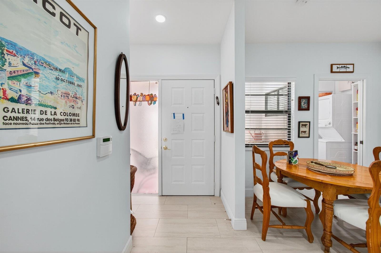 An entryway leads to a dining area with a wooden table and white chairs — 6248 Kings Gate Circle, Delray Beach FL 33484, DELRAY BEACH, FL