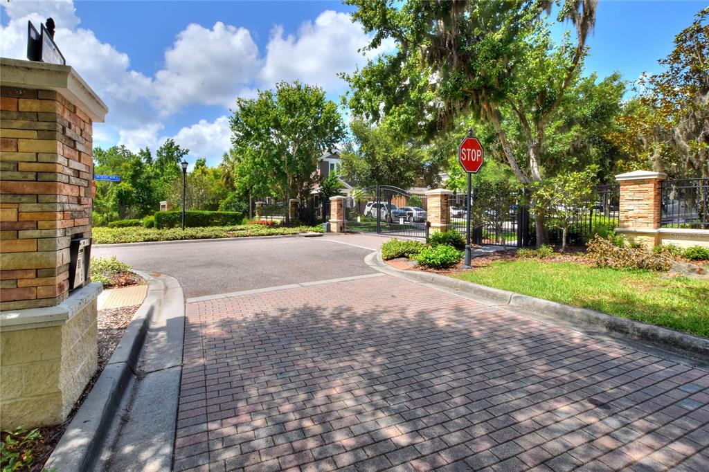A gated entrance features a brick driveway, a stop sign, and stone pillars — 16302 BAYBERRY VIEW DRIVE, LITHIA, FL