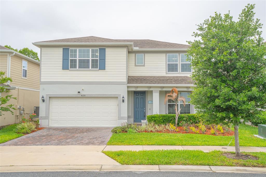 A two-story house with a two-car garage, light siding, and a blue front door — 4120 RAINFALL PLACE, SANFORD, FL