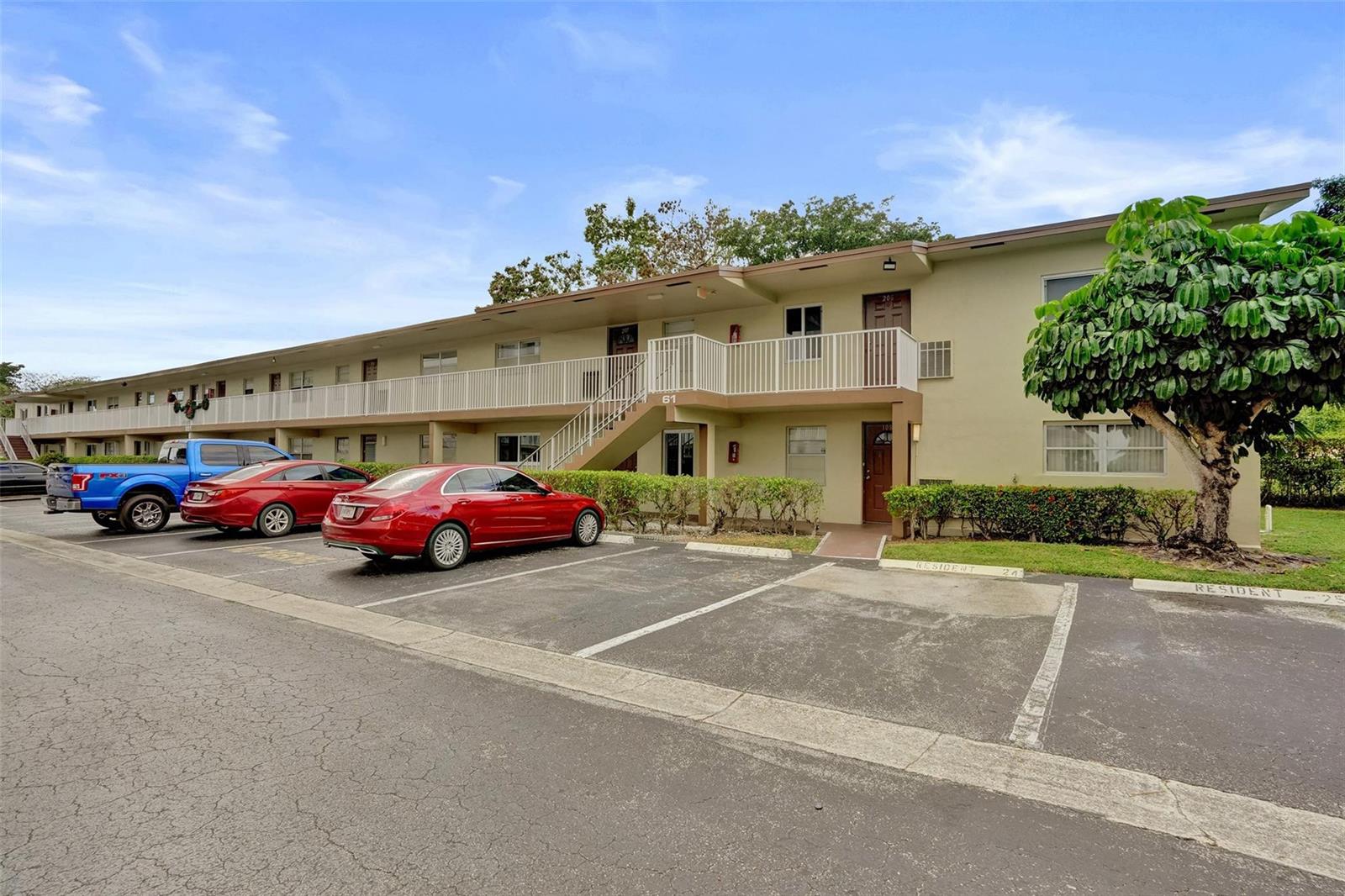 A two-story apartment building with a parking lot in the foreground and a large tree — 651 NW 80th Terrace # 207, Margate FL 33063, MARGATE, FL