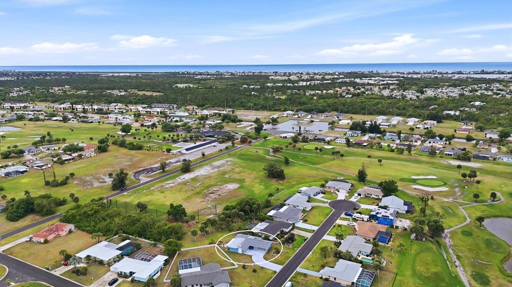 An aerial view shows a single-story house circled in a residential neighborhood near a golf course — 12 GOLFVIEW COURT, ROTONDA WEST, FL