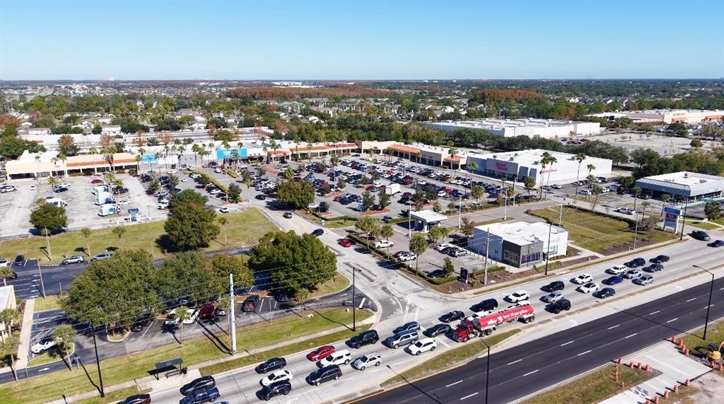 An aerial view shows a shopping center with a large parking lot and surrounding roads — 3153 W VINE STREET, KISSIMMEE, FL