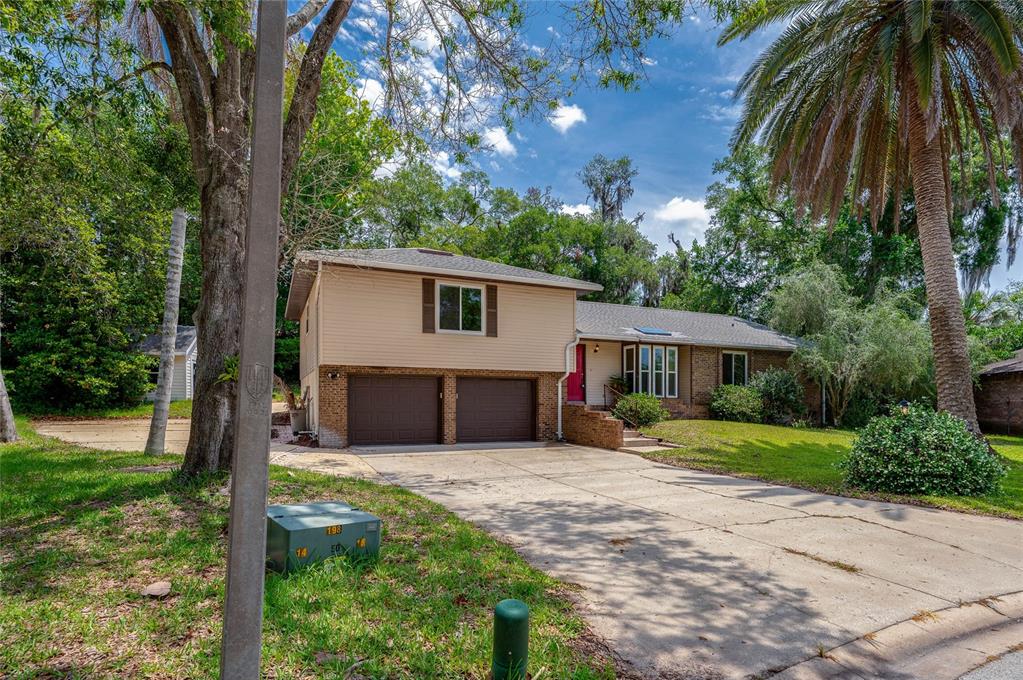 A two-story house with a two-car garage, beige siding, and a concrete driveway — 7 WATERFRONT COURT, ORMOND BEACH, FL