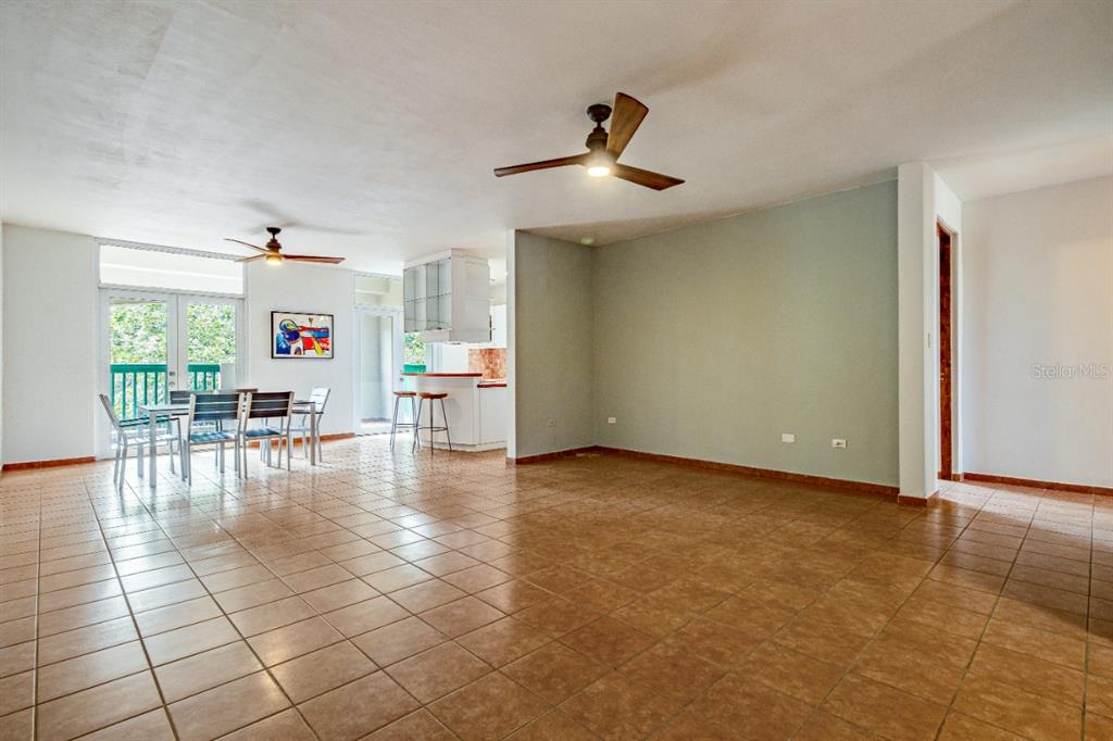 An open-concept living and dining area features tile flooring, ceiling fans, and a kitchen peninsula — 693 NCV UNIT 324, VEGA ALTA, PR