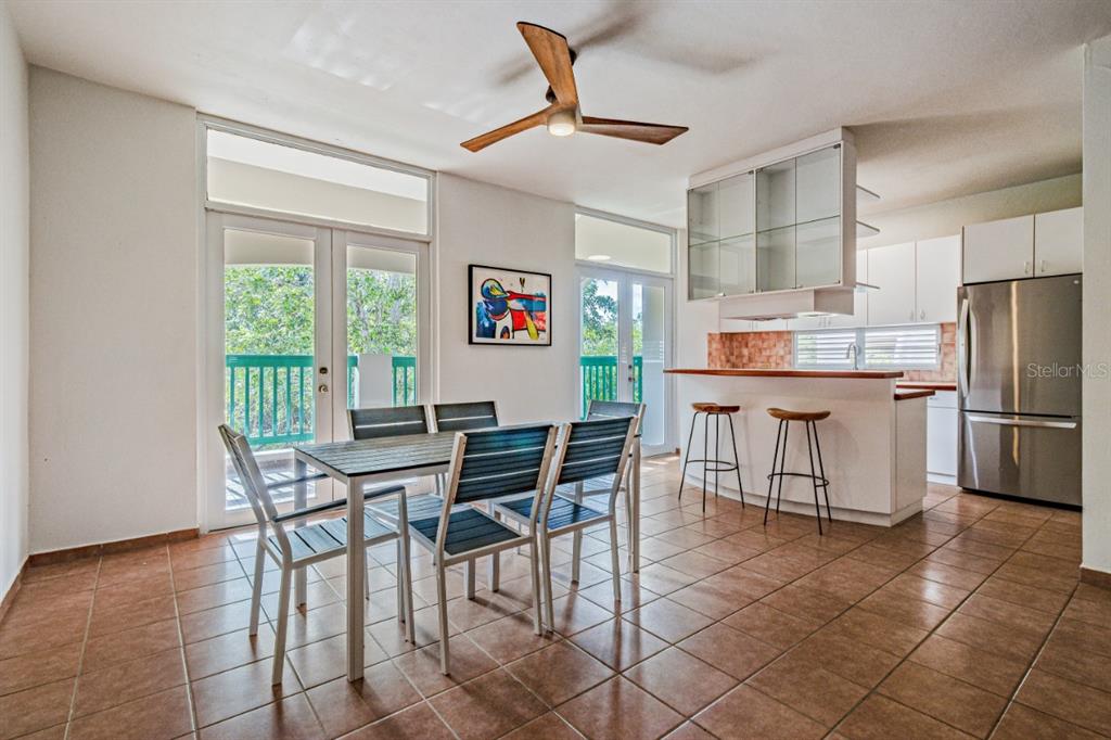 A dining area with a table and chairs sits next to a kitchen with bar seating — 693 NCV UNIT 324, VEGA ALTA, PR