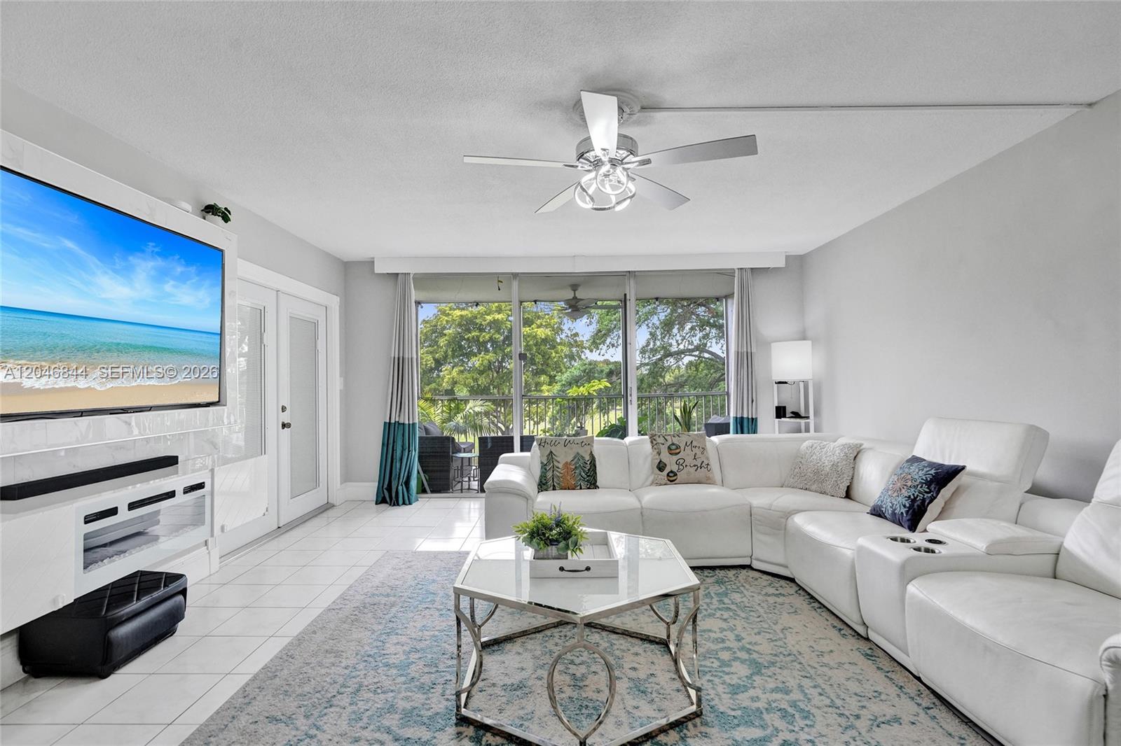 A kitchen features white cabinets, stainless steel appliances, black countertops, and a white backsplash — 2651 S Course Dr # 410, Pompano Beach FL 33069, POMPANO BEACH, FL