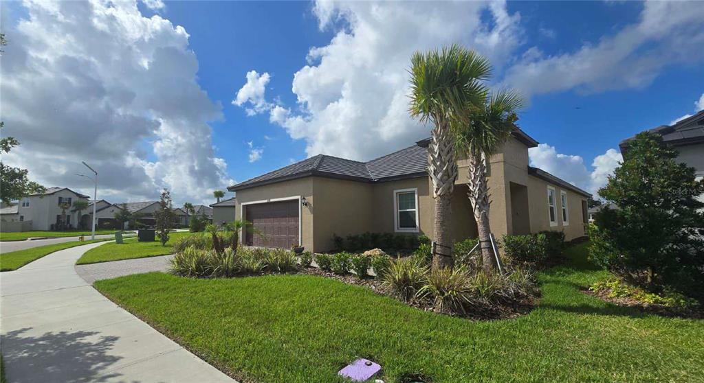 A tan, single-story house with a two-car garage and two palm trees in the yard — 10583 TUPPER CAY DRIVE, SAN ANTONIO, FL
