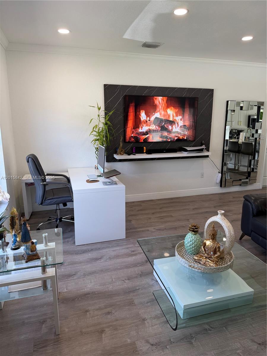 A living room features a wall-mounted television, a white desk, and a glass coffee table — 2824 SW 145th Ct # 2824, Miami FL 33175, MIAMI, FL