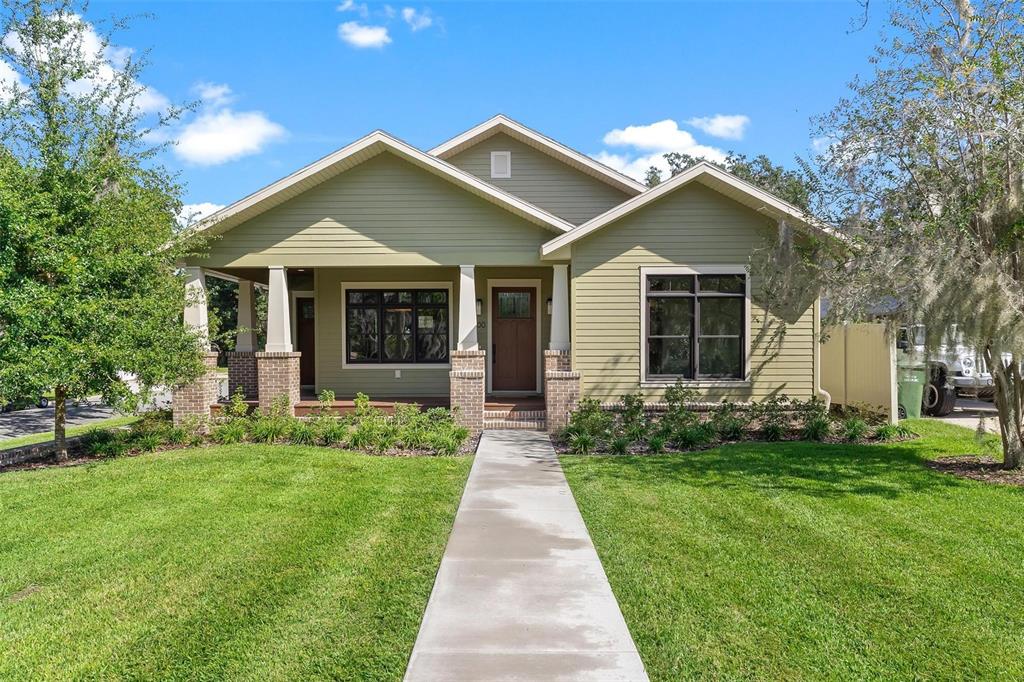 A single-story house with green siding, a front porch, and a concrete walkway — 1000 S 9TH STREET, LEESBURG, FL