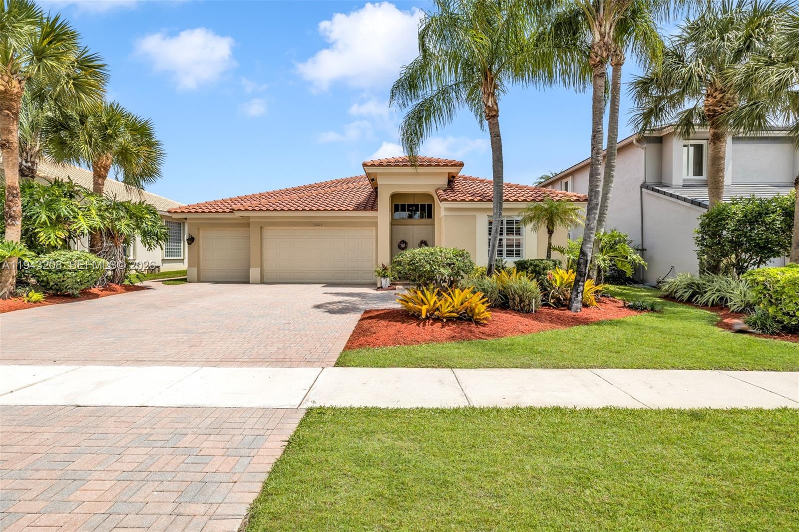 A single-story house with a tile roof, three-car garage, and landscaped front yard — 11223 Maritime Ct, Wellington FL 33449, WELLINGTON, FL