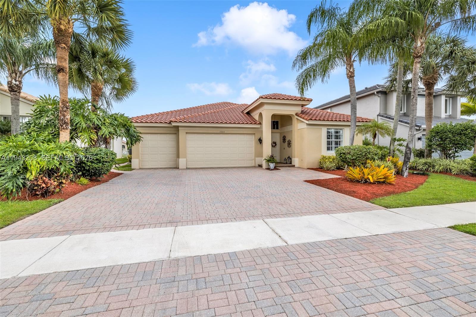 A single-story house with a tile roof, two garage doors, and a paved driveway — 11223 Maritime Ct, Wellington FL 33449, WELLINGTON, FL