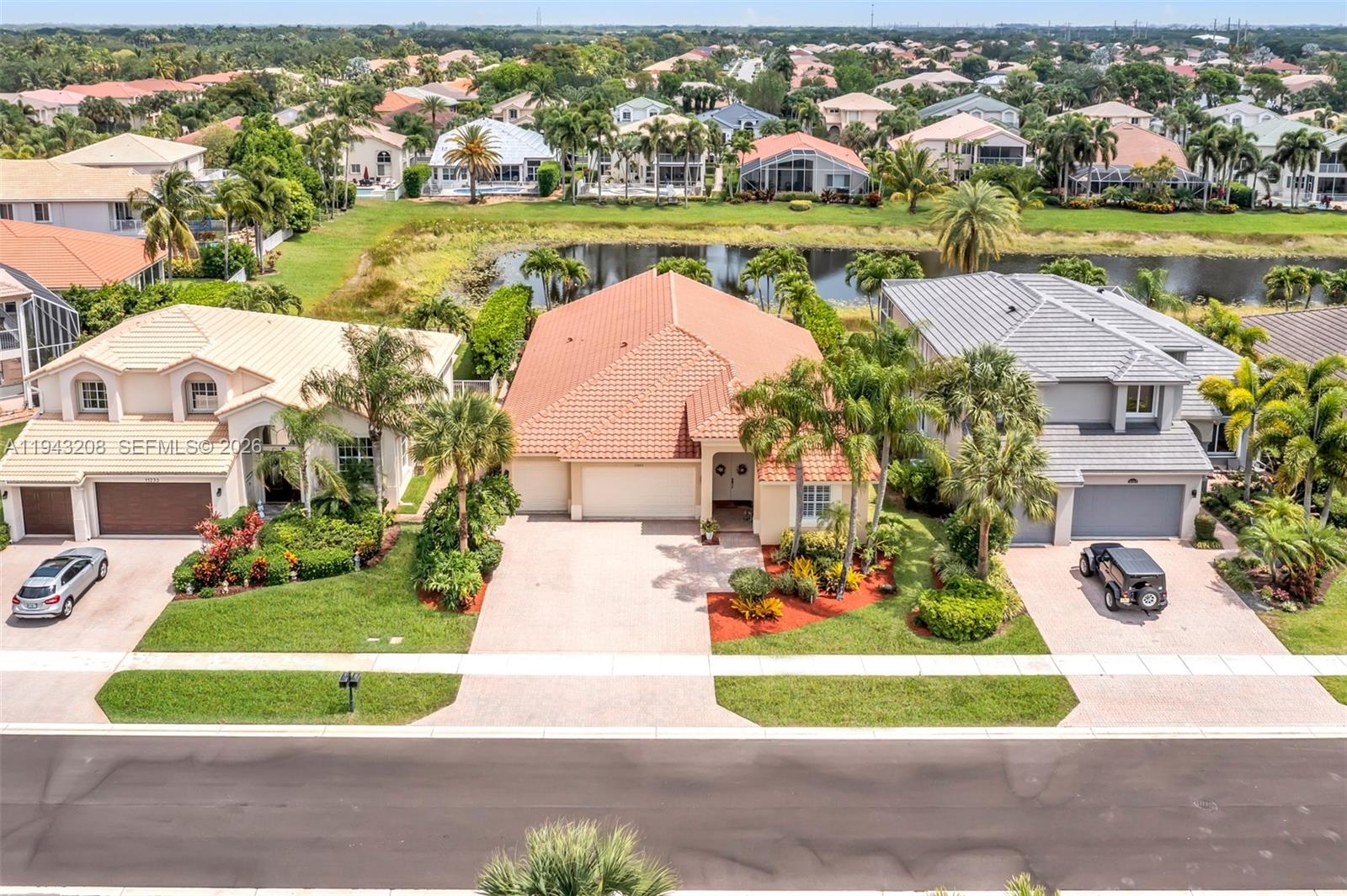 An aerial view shows three suburban houses with tiled roofs and driveways facing a street — 11223 Maritime Ct, Wellington FL 33449, WELLINGTON, FL