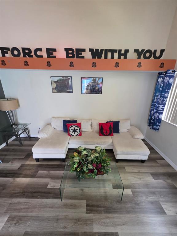 A living room features a white sectional sofa, Star Wars-themed decor, and wood-look flooring — 2751 N POINCIANA BOULEVARD UNIT 30, KISSIMMEE, FL