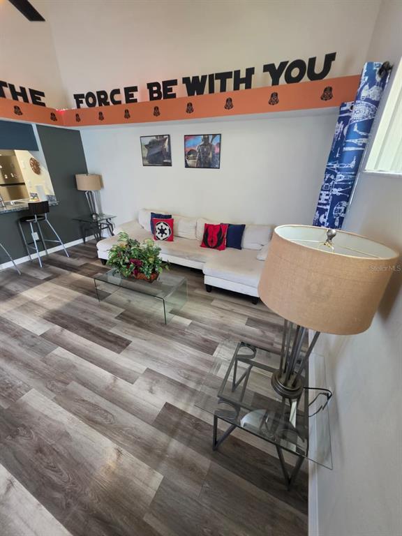A living room features wood-look flooring, a sectional sofa, and Star Wars-themed wall decor — 2751 N POINCIANA BOULEVARD UNIT 30, KISSIMMEE, FL