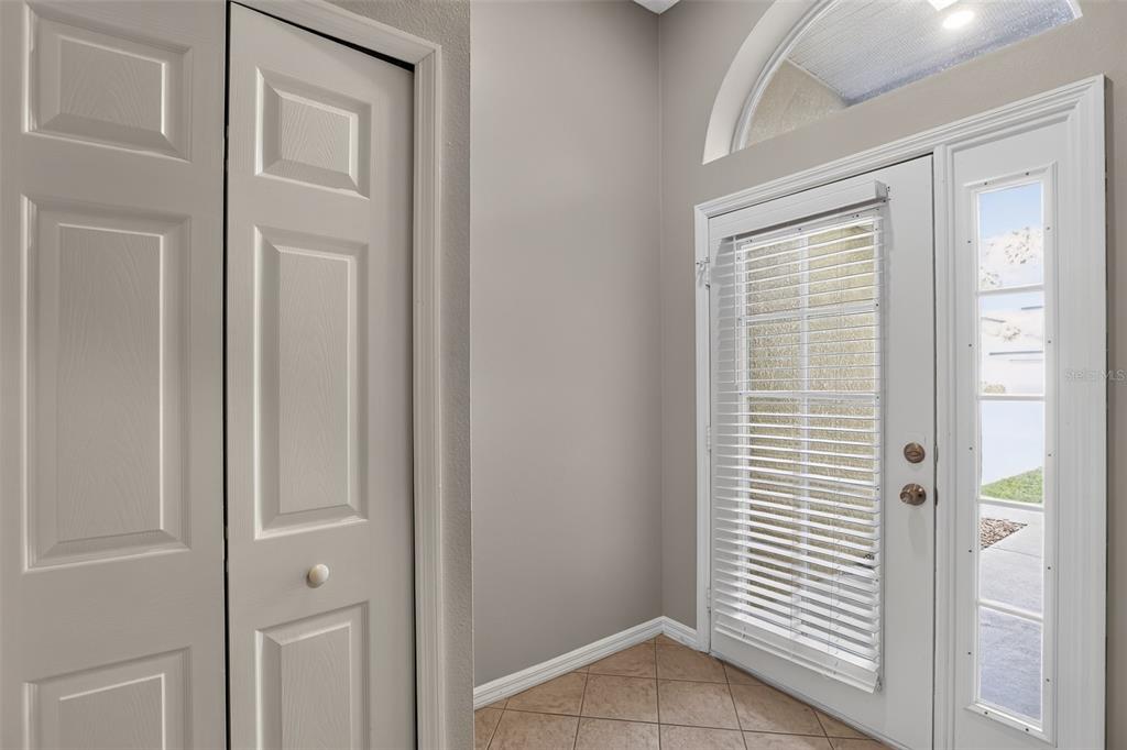 An entryway features tile flooring, a white closet door, and a front door with blinds — 1080 AMANDA KAY CIRCLE, SANFORD, FL