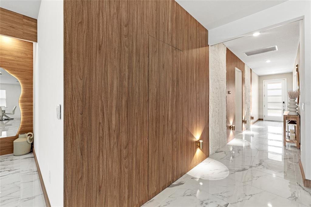 A hallway features wood-paneled walls, marble flooring, and a hidden door — 6976 ROSY SKY AVENUE, ORLANDO, FL
