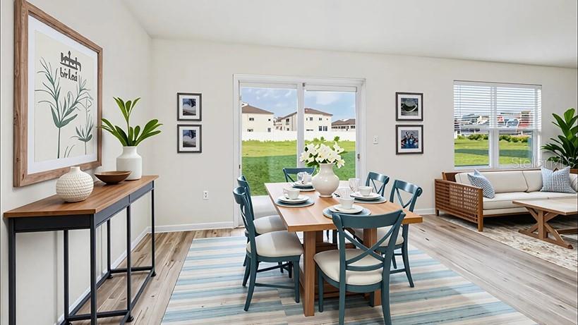 A dining area with a wooden table and chairs sits next to a living room — 24262 NW 10TH ROAD, NEWBERRY, FL